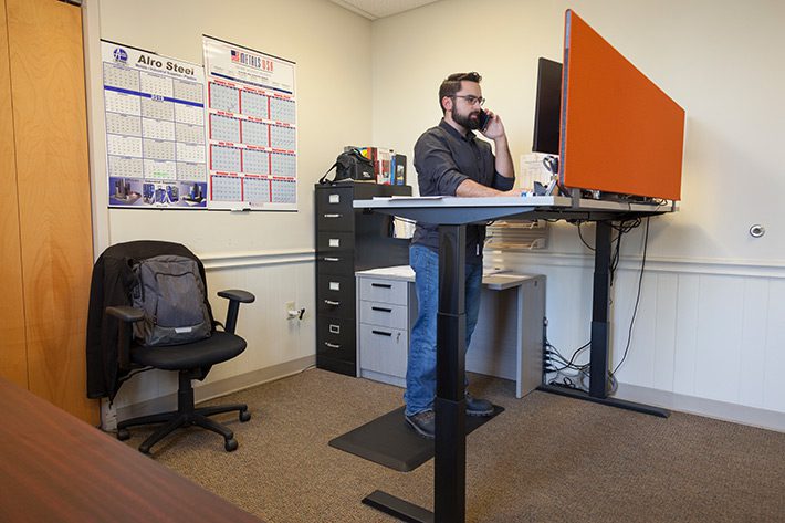 Employee estimating at his stand up desk