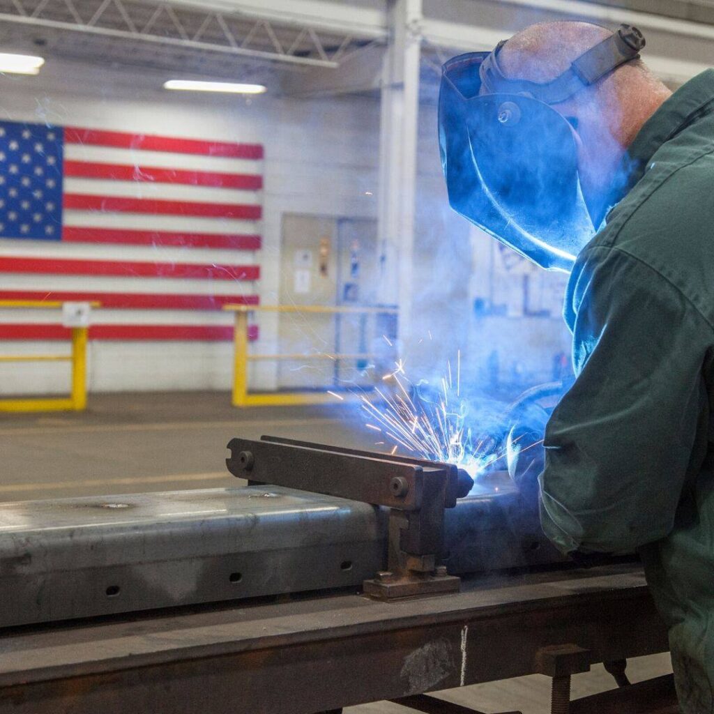 man welding large industrial equipment