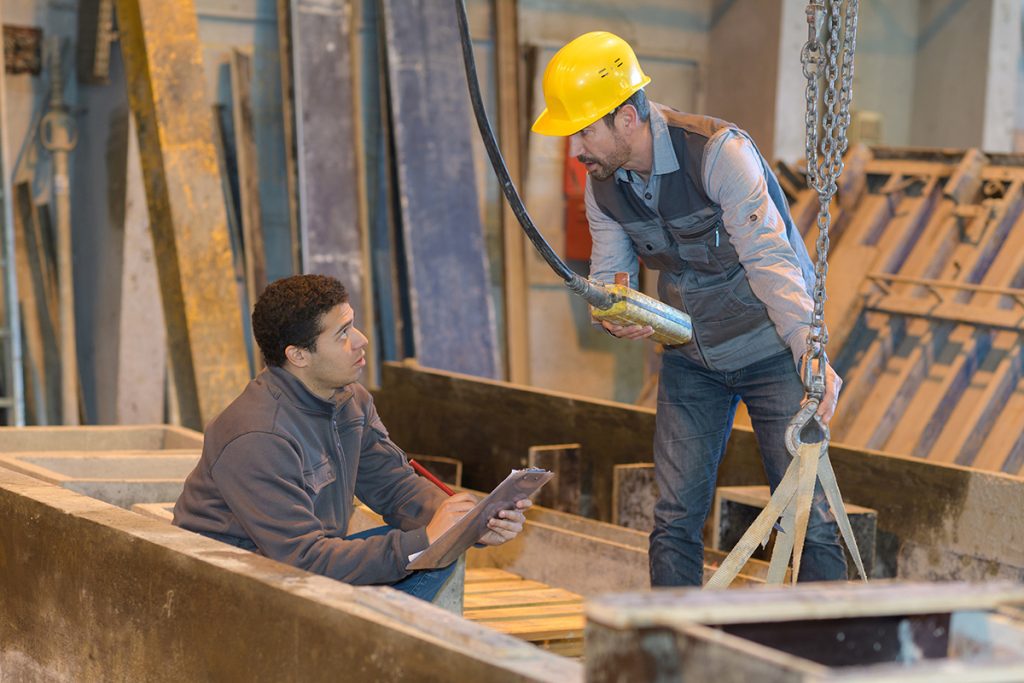 An electrician and a millwright discuss a project.