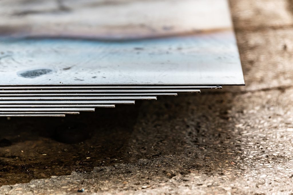 An image of several sheets of metal in a stack, waiting to be shaped.