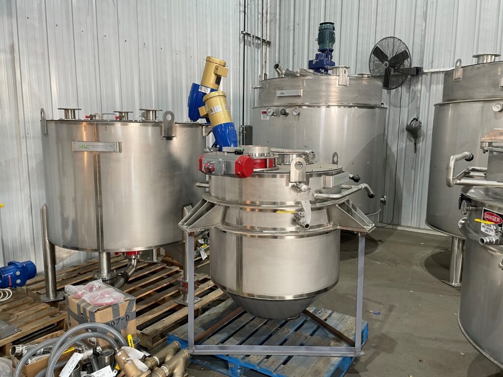 Two stainless steel lime slaker tanks with water jackets fabricated by GSM Industrial Lancaster PA, staged on shop floor prior to delivery, rated 40 PSI water jacket pressure