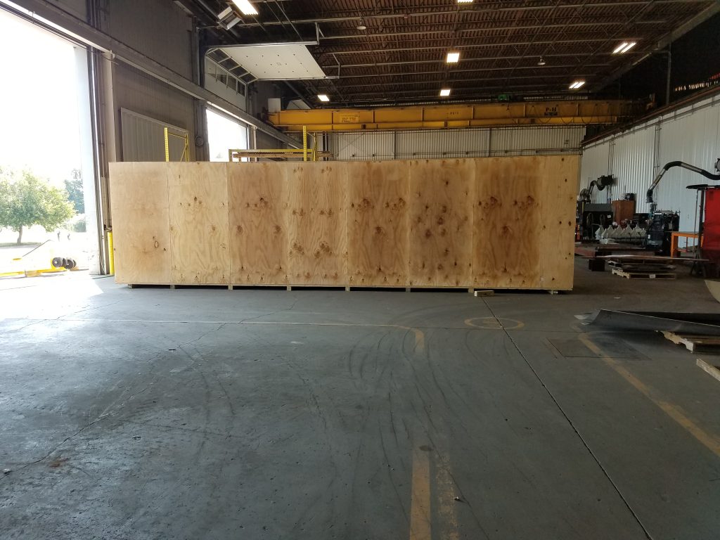 Large wooden crate prepared for shipping, containing GSM Industrial's completed ozone injection piping skid, ready for delivery to British Columbia, Canada.