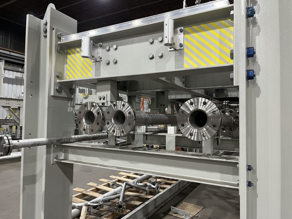 Close-up of large-diameter flanged pipe openings on a wastewater processing skid, ensuring precise equipment integration.
