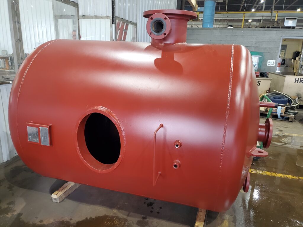 Close-up view of a freshly painted ASME U-stamped deaerator tank fabricated by GSM Industrial, awaiting final inspection inside the shop.