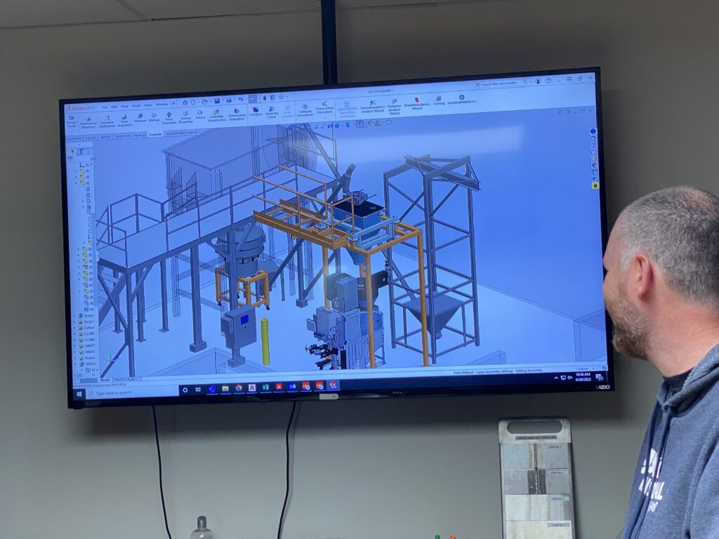 A person looks at a screen with a digitally rendered project on the screen.