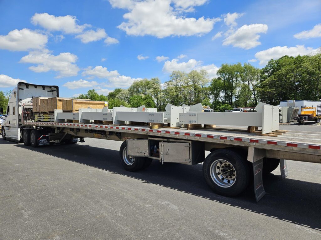Flatbed truck loaded with AISC-certified structural steel components for shipment